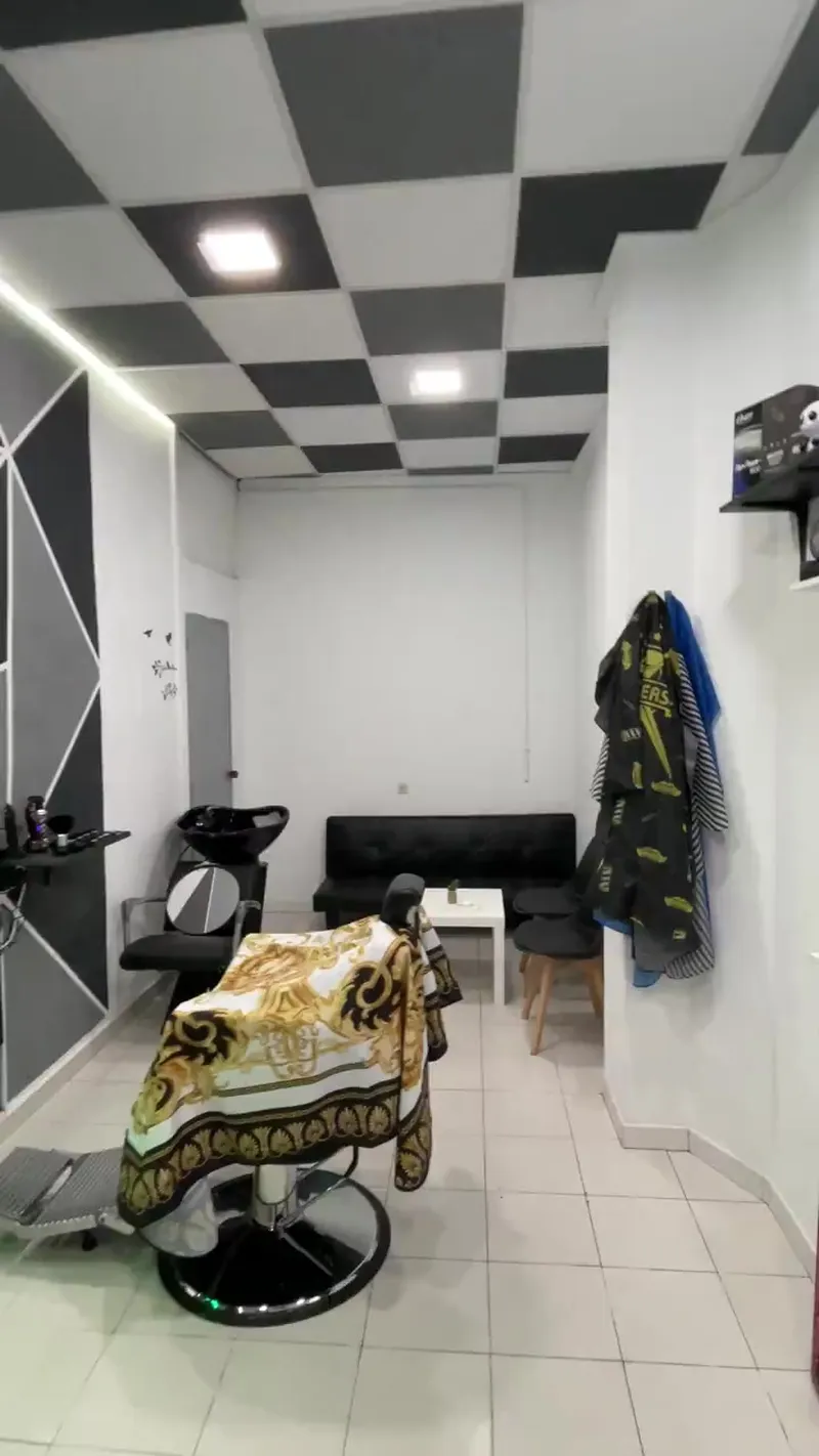 Sala de espera con sofá negro al fondo del local